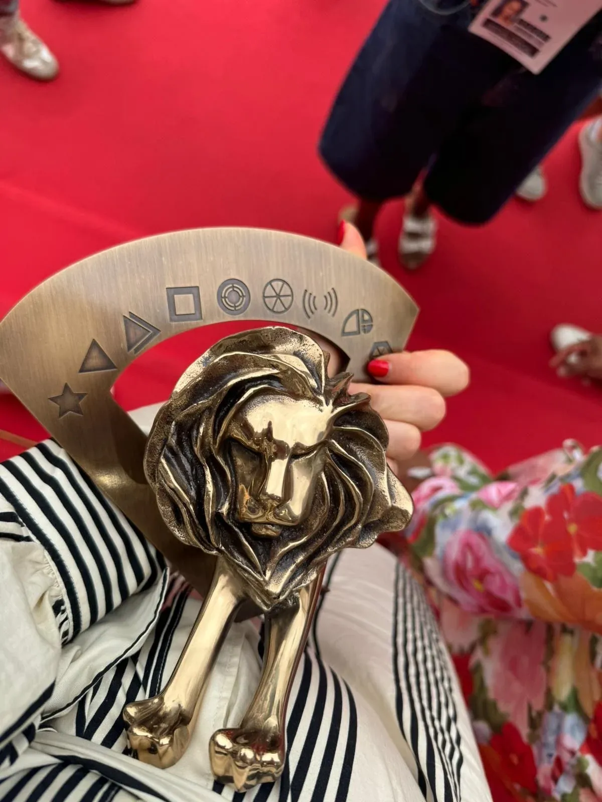 A bronze Cannes Lions trophy held in hand on the red carpet
